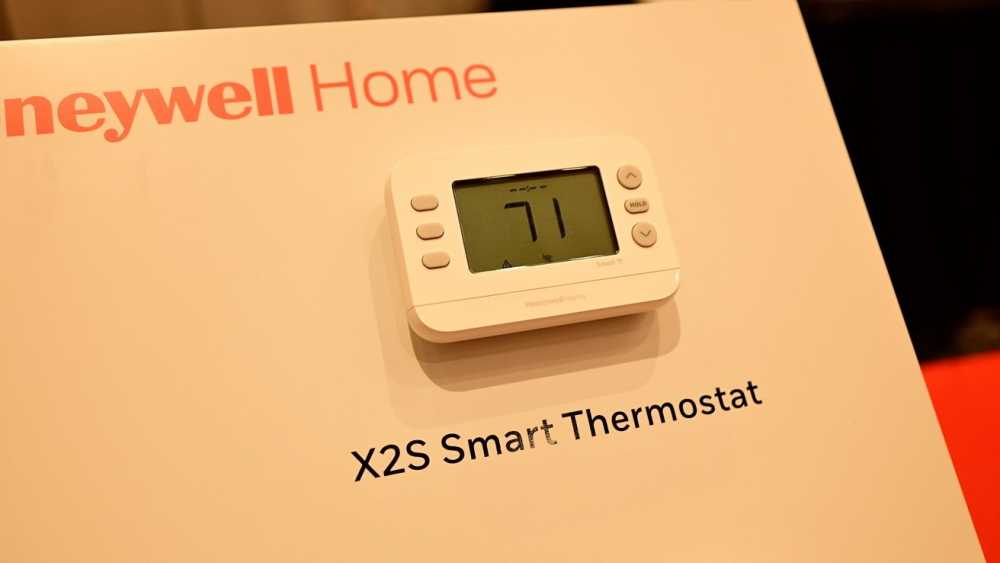 Honeywell Home X2S智能恒温器显示71度，安装在白色墙板上。