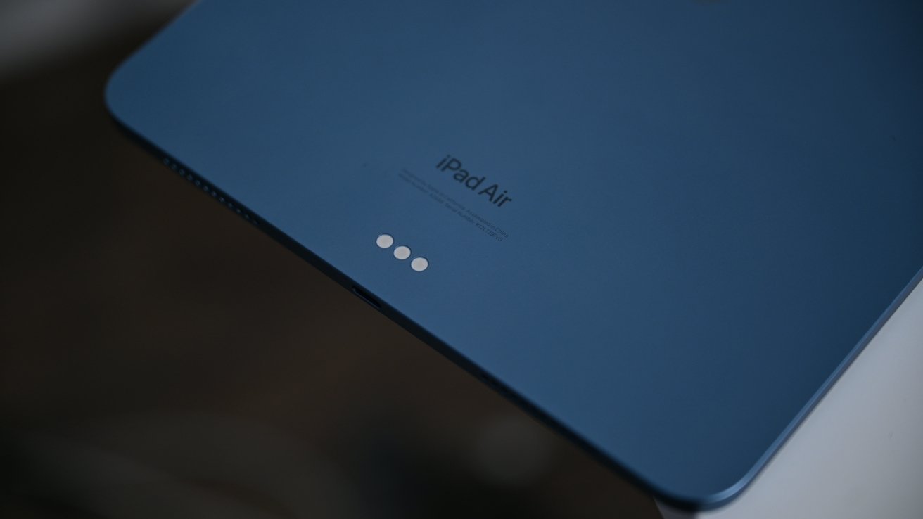 蓝色平板电脑背面，带有“iPad Air”字样和靠近边缘的三个小圆形连接器。