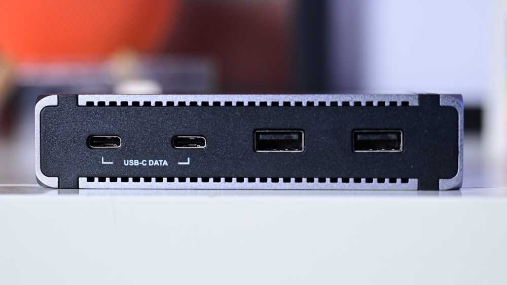 A close-up of a device showing two USB-C ports labeled for data and two standard USB ports, on a black and grey background.