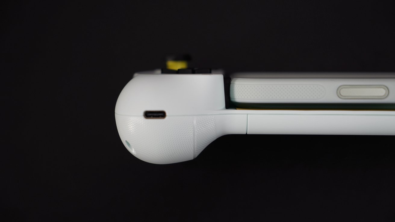 浅绿色游戏手柄侧视图的特写，具有圆形的握把、USB-C 端口和按钮的一部分，位于黑色背景上。