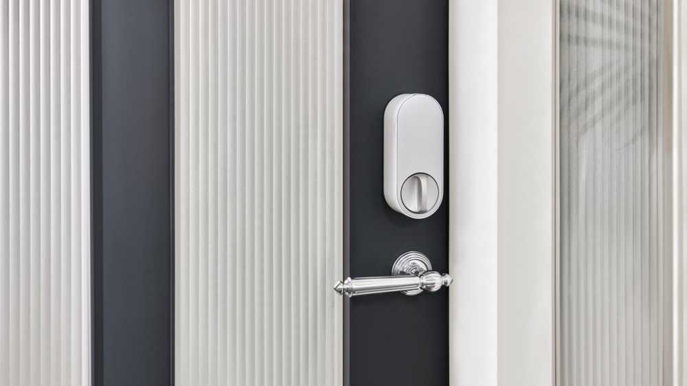 Modern door with vertical fluted panels, a silver hinge, and a sleek silver handle featuring a round lock.