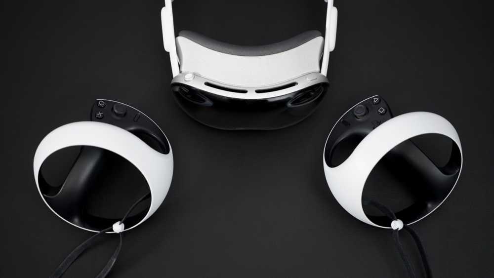 A VR 头显 and two white controllers with black grips are positioned on a dark surface.