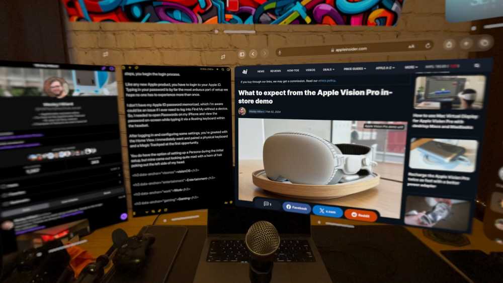 Desk with computer monitors, one displaying an article about Apple Vision Pro, surrounded by gaming controllers, a microphone, and colorful wall art in the background.