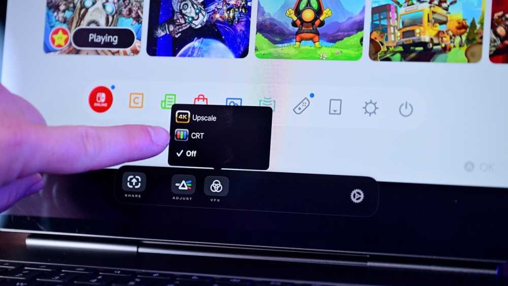 Finger selecting display settings on a screen, including options for 4K upscaling, CRT, and off. Background shows colorful game icons.