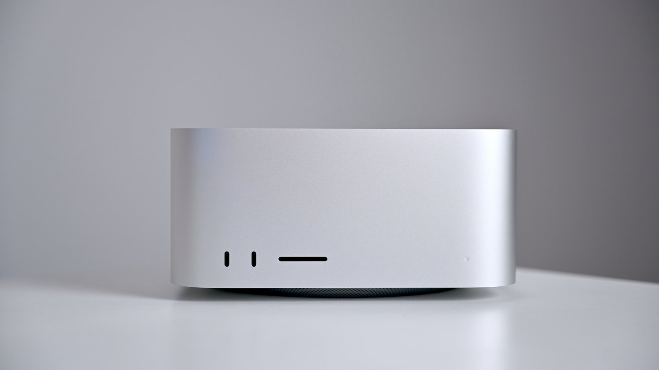 Silver rectangular electronic device on a white surface with two vertical and one horizontal slot on the front.