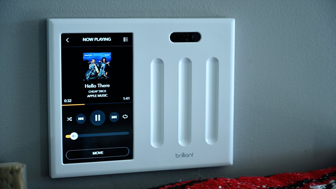 Wall-mounted smart home control panel displaying music by Cheap Trick, playing progress, and playback controls.