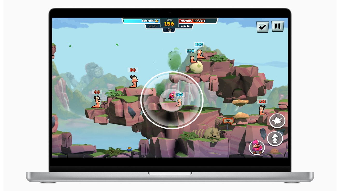 Cartoon worms on rocky platforms in a colorful landscape, with various health numbers above them and game interface elements visible on a laptop screen.