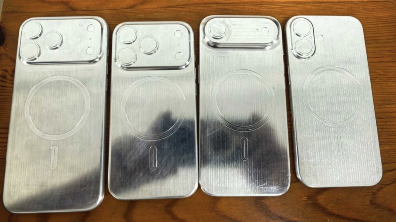 Four silver metal smartphone molds on a wooden surface, each with varying camera and port placements.