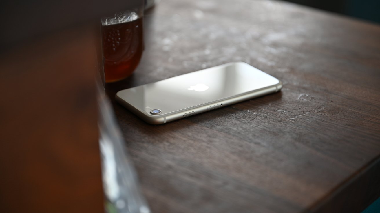 银色iPhone背面朝上放置在木桌