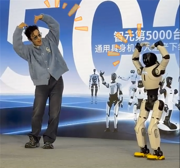 黄晓明与智元第5000台人型机器人同步比心：我很喜欢它的黄色鞋子  因为我姓黄